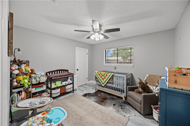 3614 Capri Dr, Corpus Christi, TX 78415 - bedroom with a crib, a textured ceiling, wood finished floors, and a ceiling fan