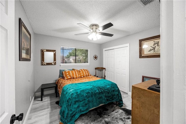 3614 Capri Dr, Corpus Christi, TX 78415 - bedroom featuring light wood finished floors, a closet, a ceiling fan, and a textured ceiling