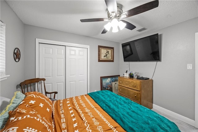 3614 Capri Dr, Corpus Christi, TX 78415 - bedroom featuring a closet, ceiling fan, wood finished floors, and a textured ceiling