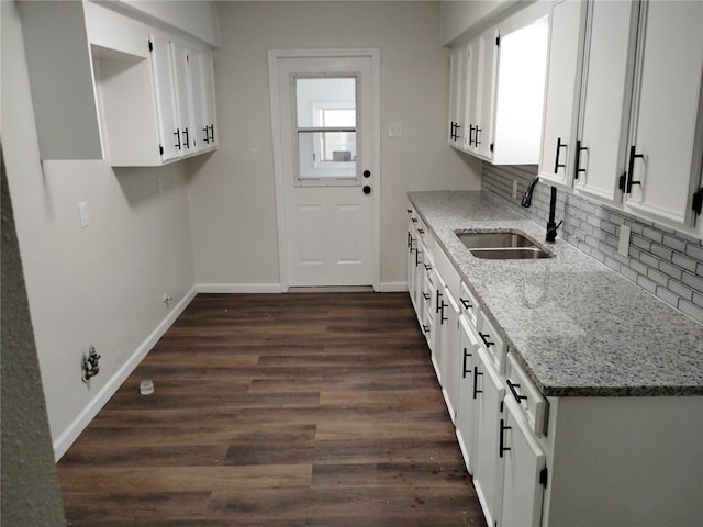 1540 Daytona Dr, Corpus Christi, TX 78415 - kitchen with a sink, light stone counters, decorative backsplash, baseboards, and dark wood-style floors