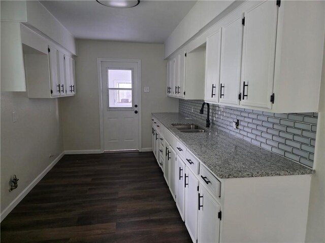 1540 Daytona Dr, Corpus Christi, TX 78415 - kitchen featuring a sink, light stone countertops, baseboards, backsplash, and white cabinetry