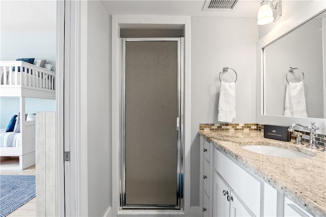 ensuite bathroom with visible vents, ensuite bathroom, vanity, and a shower stall