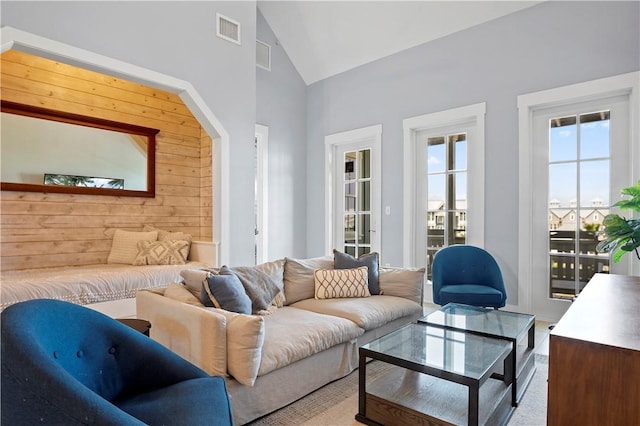 living area with visible vents and high vaulted ceiling