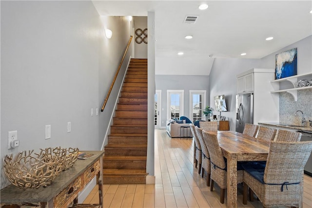 dining area with visible vents, stairway, vaulted ceiling, recessed lighting, and light wood-style floors