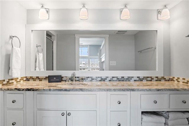 full bathroom featuring decorative backsplash, visible vents, and vanity