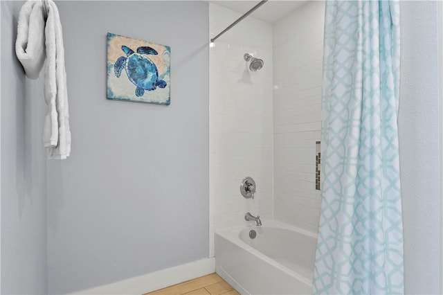 full bath with shower / tub combo and baseboards