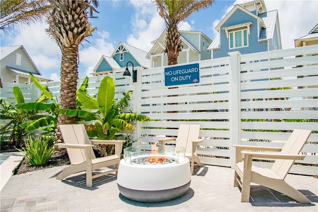 view of patio featuring an outdoor fire pit and fence