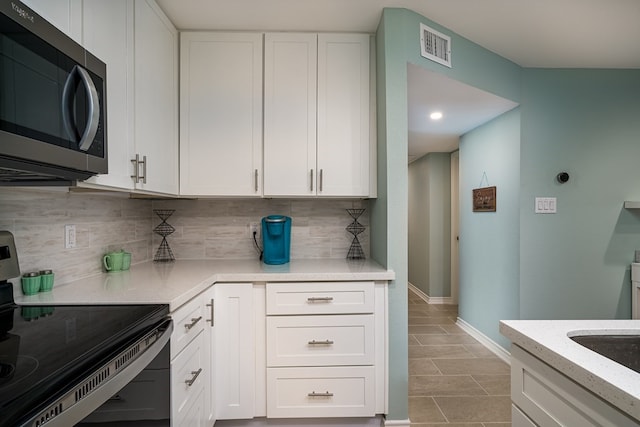 kitchen featuring range with electric stovetop, tasteful backsplash, sink, and white cabinets