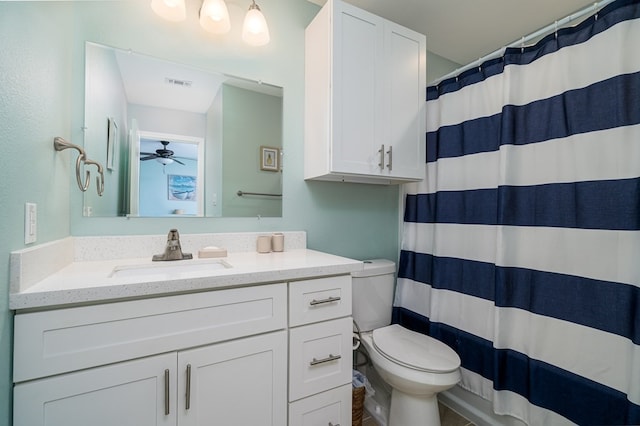 bathroom with walk in shower, ceiling fan, vanity, and toilet