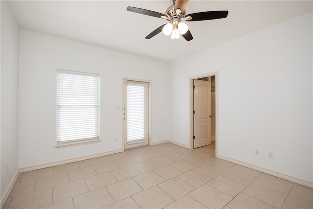 spare room with ceiling fan and light tile patterned floors