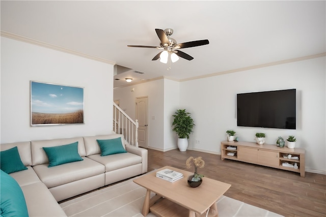 living room with ornamental molding, light hardwood / wood-style flooring, and ceiling fan