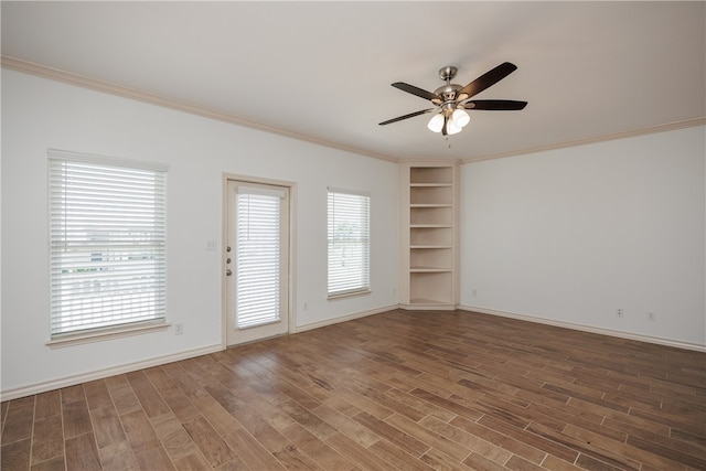 spare room featuring dark wood-type flooring, ceiling fan, and crown molding