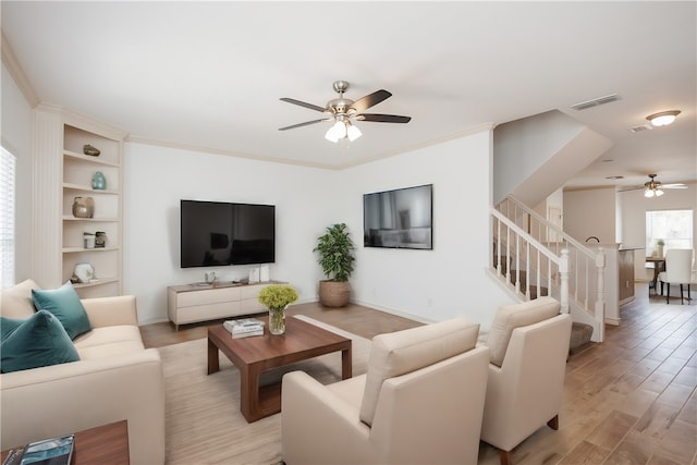 living room with ornamental molding, ceiling fan, and light hardwood / wood-style floors