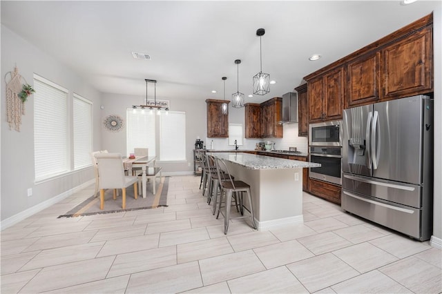 3141 Piranha Dr, Corpus Christi, TX 78414 - kitchen with stainless steel appliances, wall chimney range hood, baseboards, a sink, and light stone countertops