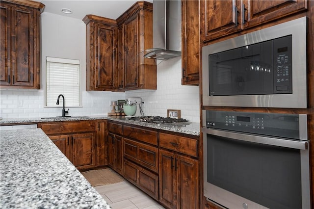 3141 Piranha Dr, Corpus Christi, TX 78414 - kitchen with appliances with stainless steel finishes, wall chimney range hood, a sink, and tasteful backsplash