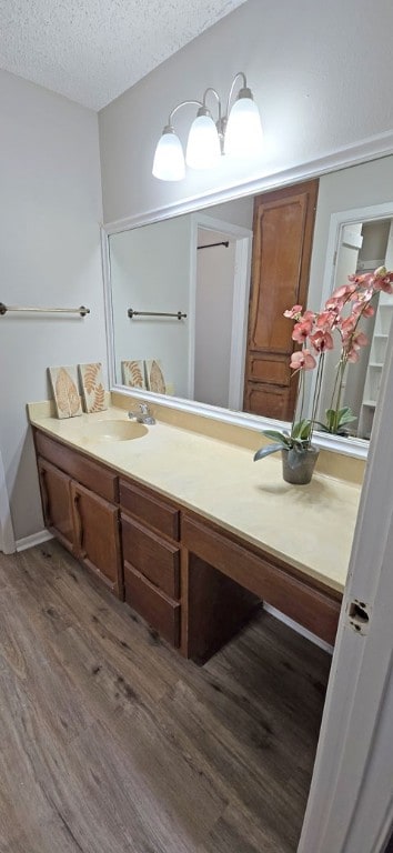 bathroom featuring hardwood / wood-style floors, vanity, and a textured ceiling