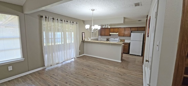 kitchen with kitchen peninsula, light wood-type flooring, decorative light fixtures, white appliances, and a chandelier