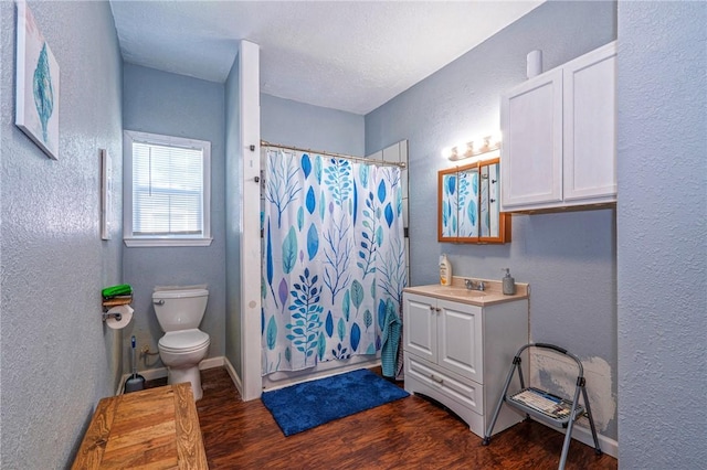 10634 Veda Dr, Corpus Christi, TX 78410 - bathroom with a textured wall, wood finished floors, toilet, vanity, and a shower with curtain
