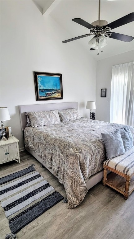 bedroom featuring hardwood / wood-style flooring, ceiling fan, and beam ceiling