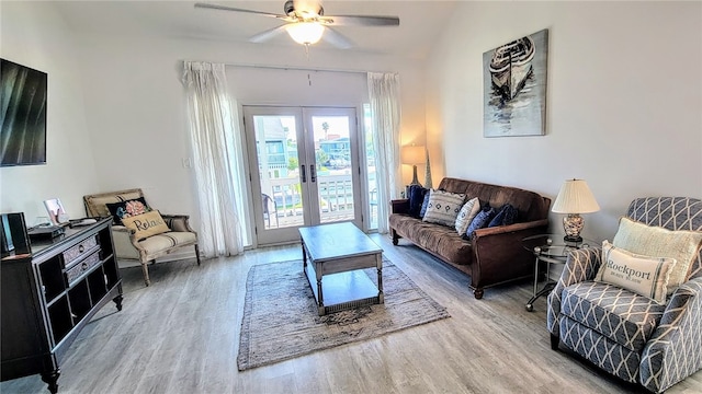 living room featuring ceiling fan, vaulted ceiling, wood-type flooring, and french doors