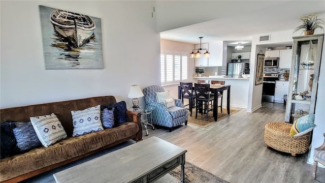 living room with light hardwood / wood-style flooring and a notable chandelier