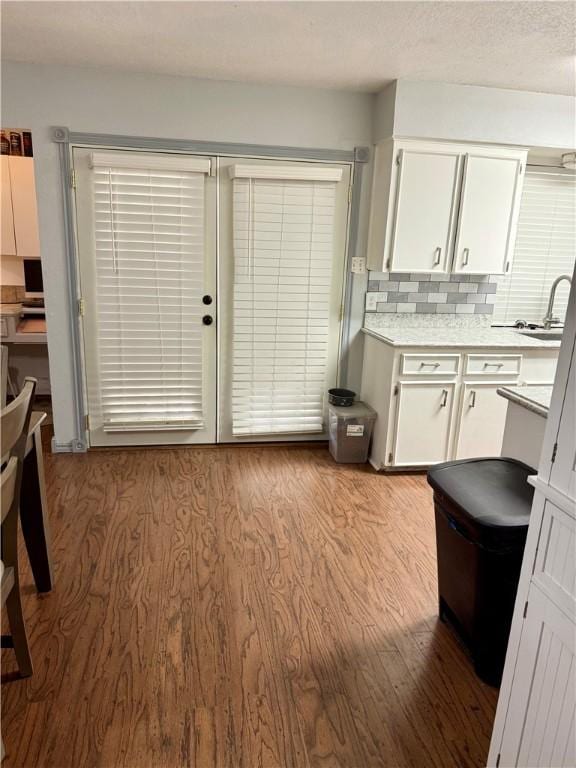 11614 Coleta Creek Dr, Corpus Christi, TX 78410 - kitchen featuring white cabinetry, wood finished floors, light countertops, and tasteful backsplash