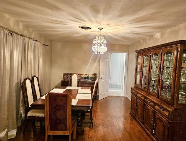 4725 Shea Pkwy, Corpus Christi, TX 78413 - dining area featuring a chandelier, a textured ceiling, dark wood-style flooring, and visible vents