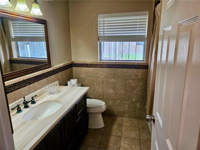 4725 Shea Pkwy, Corpus Christi, TX 78413 - bathroom featuring toilet, tile patterned floors, tile walls, a textured wall, and vanity