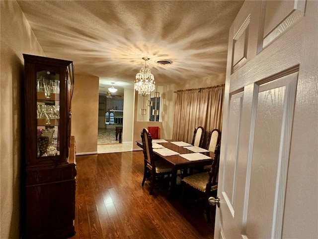 4725 Shea Pkwy, Corpus Christi, TX 78413 - dining space featuring dark wood finished floors, a chandelier, visible vents, and a textured ceiling
