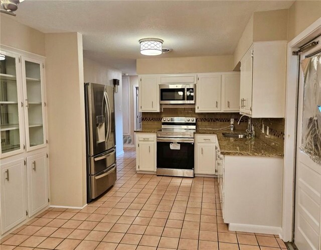 4725 Shea Pkwy, Corpus Christi, TX 78413 - kitchen with a sink, stainless steel appliances, light tile patterned floors, and white cabinets