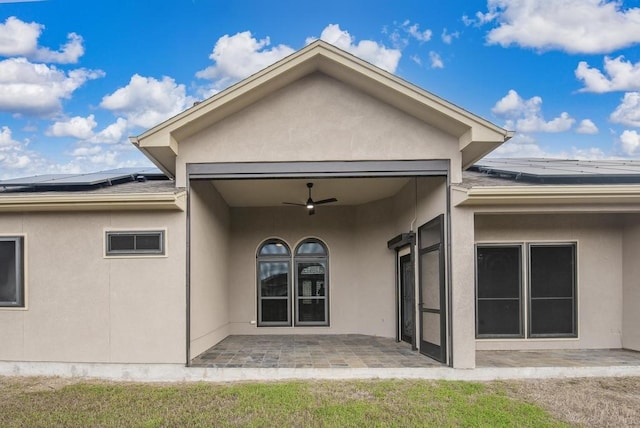 rear view of property with a patio area, ceiling fan, and solar panels