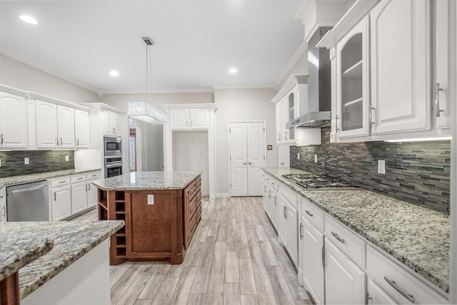 kitchen with white cabinets, crown molding, light hardwood / wood-style flooring, decorative light fixtures, and stainless steel appliances