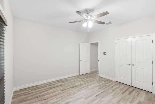 unfurnished bedroom with a closet, light hardwood / wood-style floors, and ceiling fan