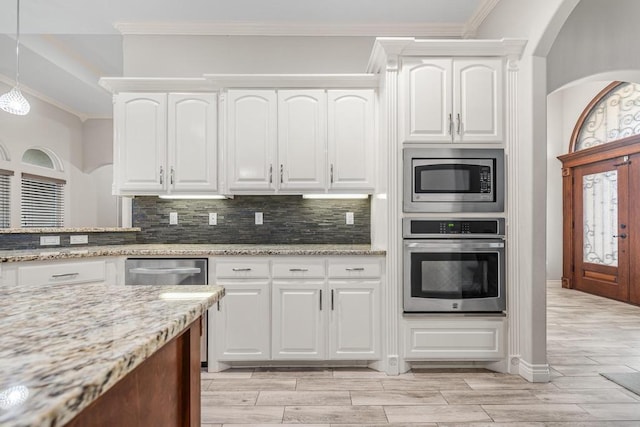 kitchen featuring appliances with stainless steel finishes, light stone counters, decorative light fixtures, light hardwood / wood-style floors, and white cabinetry