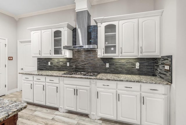 kitchen with white cabinets, stainless steel gas stovetop, and wall chimney exhaust hood