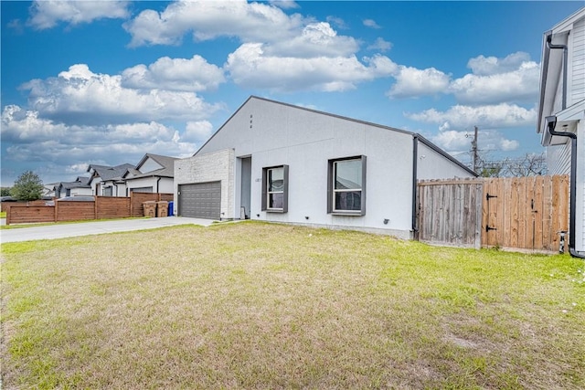 view of front facade with a garage, concrete driveway, a front yard, and fence