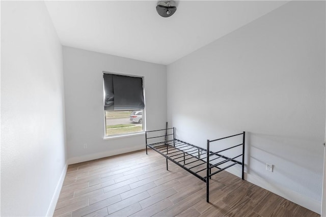 bedroom featuring baseboards and wood finished floors