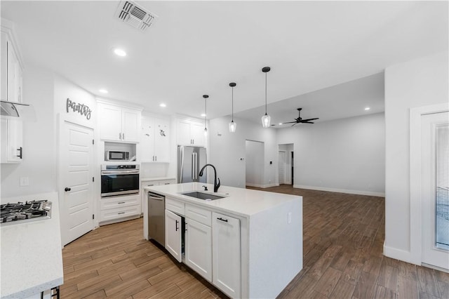 kitchen with light wood finished floors, visible vents, appliances with stainless steel finishes, and a sink