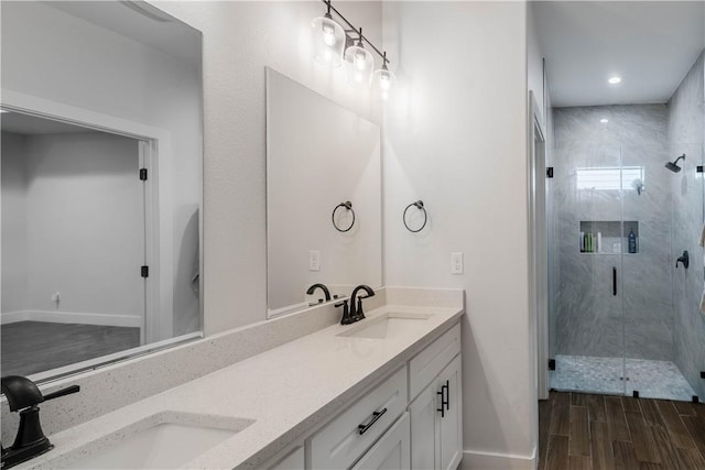 bathroom featuring a shower stall, wood finished floors, and a sink