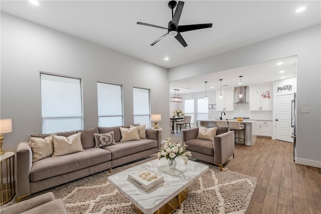 living area with recessed lighting, light wood-style flooring, and ceiling fan