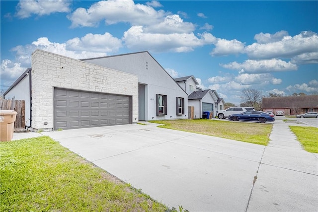 view of front facade with stucco siding, stone siding, concrete driveway, a front yard, and an attached garage