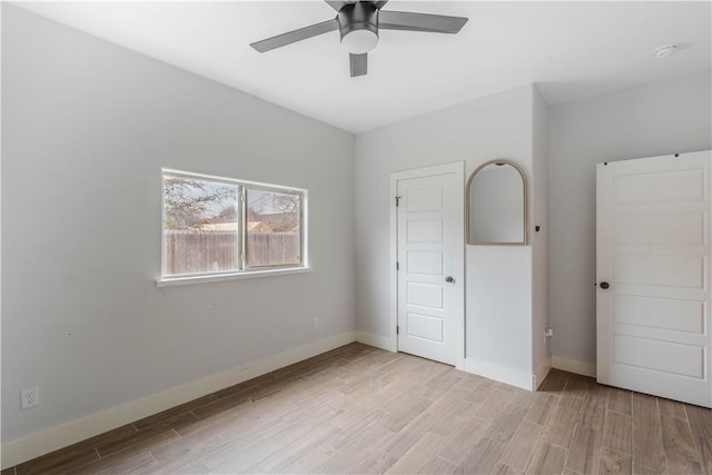 unfurnished bedroom featuring light wood-style floors, baseboards, and ceiling fan