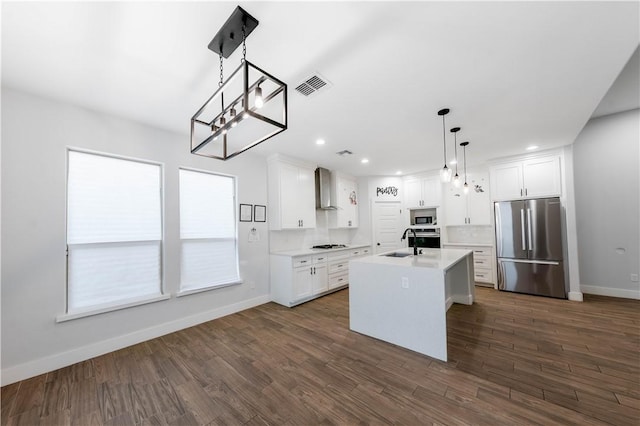 kitchen featuring visible vents, light countertops, appliances with stainless steel finishes, white cabinetry, and wall chimney exhaust hood