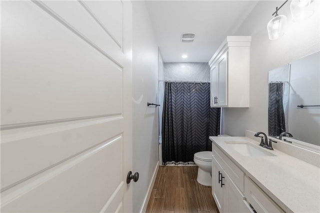 full bath featuring a shower with curtain, toilet, wood finished floors, baseboards, and vanity