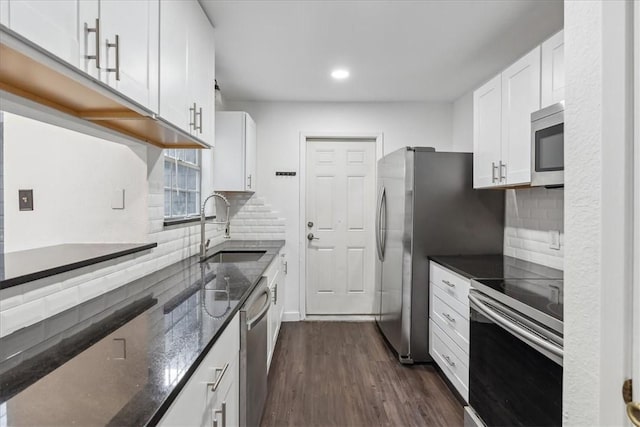 kitchen with backsplash, dark wood-type flooring, sink, appliances with stainless steel finishes, and white cabinetry