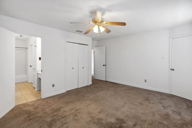 unfurnished bedroom with light carpet, ensuite bathroom, and ceiling fan