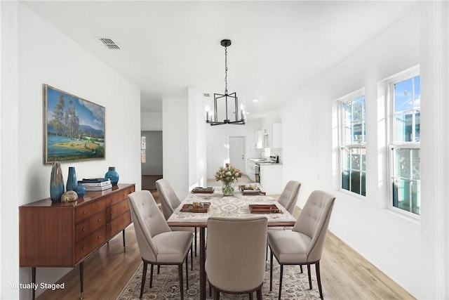 dining room with a chandelier and light hardwood / wood-style floors