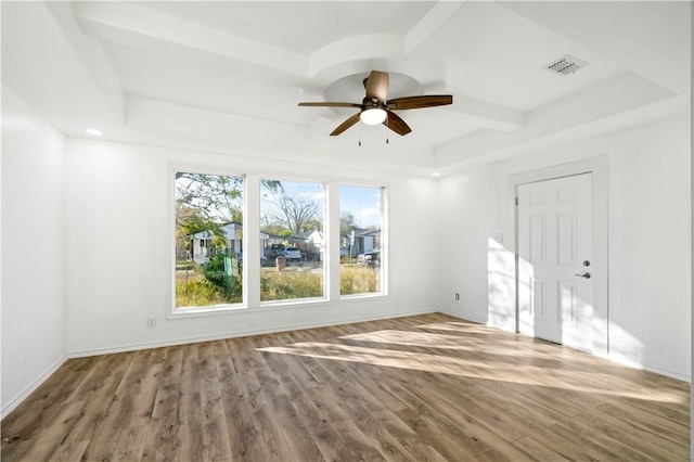 unfurnished room featuring a raised ceiling, ceiling fan, and hardwood / wood-style floors