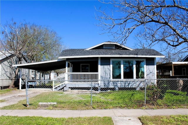 view of front of house with a carport, covered porch, and a front lawn