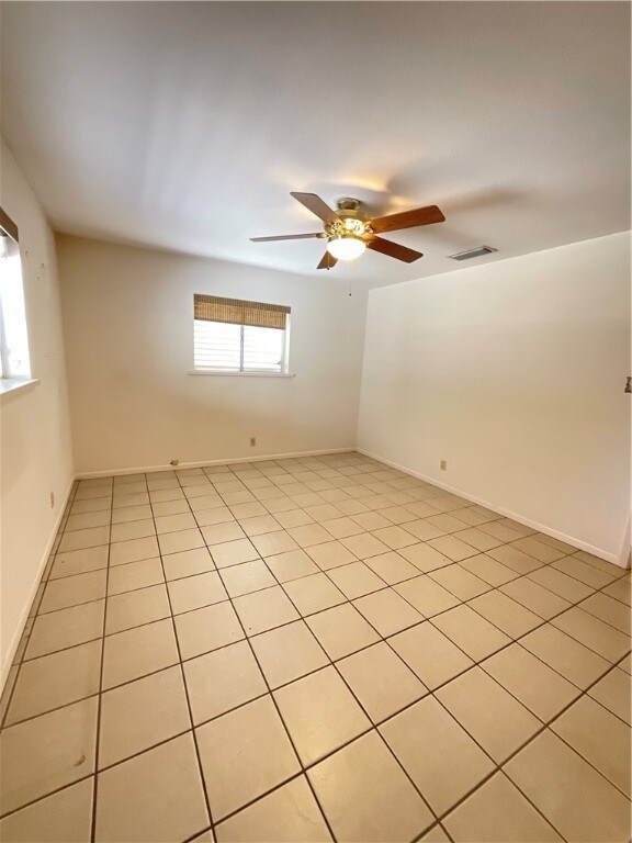 tiled empty room with ceiling fan